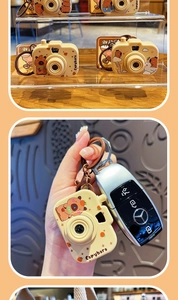 Miniature Capybara camera keychain accessory shown attached to a canvas bag and car keys