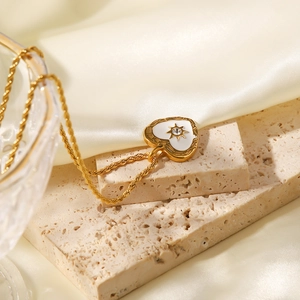 Vintage heart pendant necklace with white enamel and crystal on a gold twisted chain