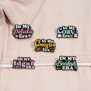 Detailed close-up of colorful enamel pins on a pink denim jacket showing diverse design themes