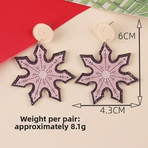 Macro detail of acrylic snowflake earrings with pink purple glitter and beige studs