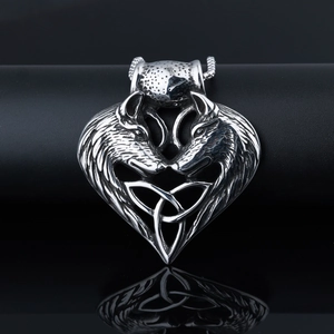 Detail of vintage silver wolf head heart necklace with Celtic knot engraving and mirror finish