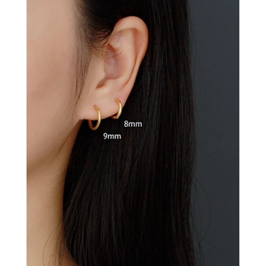 Detail of 8mm and 9mm gold S925 sterling silver hoop earrings worn on double ear piercings