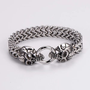 Gothic punk wheat chain bracelet featuring detailed steel skulls and a circular spring clasp