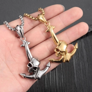 Gotische Totenkopf und Anker Anhänger in Gold und Silber auf dunklem Holz Hintergrund