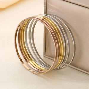 Detailed view of stacked polished titanium steel rings in gold, silver, and rose gold finishes