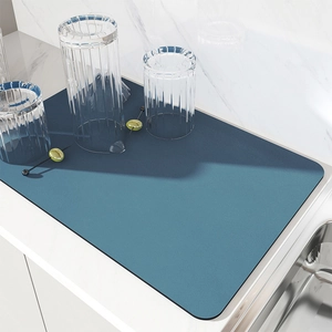 Detailed view of a blue absorbent kitchen drying mat on a modern white countertop