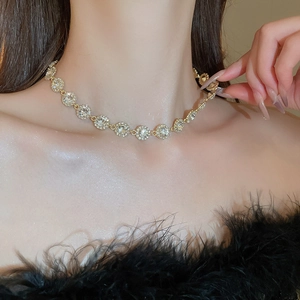 Gros plan d'un collier ras du cou doré étincelant avec cristaux sur le cou du mannequin