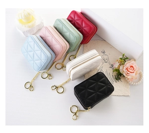 Flat lay of mini quilted makeup bags with mirrors and gold chains in various colors
