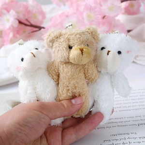 Detailed close-up of plush teddy bear charms in white and brown with metal chains