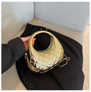 Detailed view of golden metallic half-moon clutch featuring quilted rhombic patterns and chain