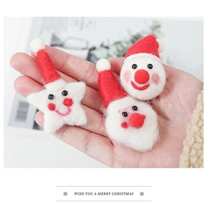Detailed view of handmade red and white felt Santa and star ornaments for Christmas