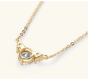 Macro view of gold heart pendant back showing hollow structure and zircon settings