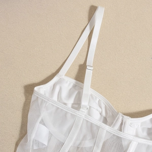 Close-up of white mesh bodysuit showing adjustable straps and fine stitching detail