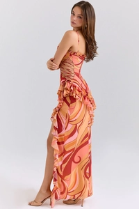 Detail of the ruffle hem and side cutout on this orange abstract print maxi dress