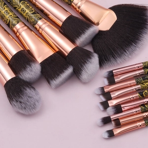 Macro detail of 15-piece black and gold makeup brushes with mandala floral pattern handles