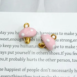 Close-up of pink mushroom pendants with gold metal ring and cute white polka dots
