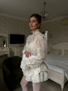 Close-up of elegant white lace tiered skirt detail with intricate floral patterns