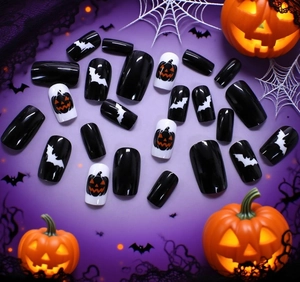Detail view of glossy Halloween press-on nails with pumpkin and bat patterns