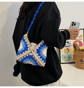 Detailed macro view of handmade crochet shoulder bag featuring 3D floral textures and pearl button