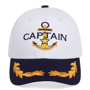 Detail of embroidered CAPTAIN text and golden anchor emblem on white navy hat