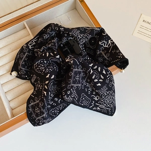 Detail of bohemian black printed hair claw clip with white pearl pendants in a wooden box
