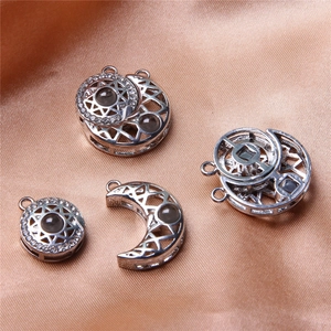 Detailed silver sun and moon charms with inlaid crystals on soft pink satin fabric