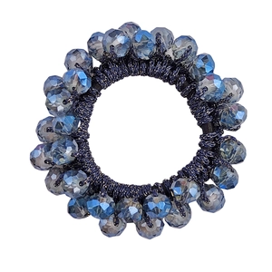 Macro shot of deep blue crystal beaded hair tie with elastic rope on white background