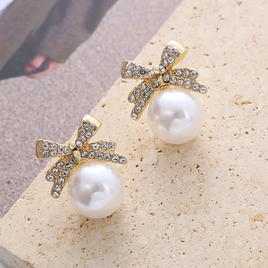 Vue détaillée de boucles d'oreilles nœud élégantes avec zircons et perles suspendues