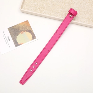 Detailed close-up of pink leather phone wrist strap with stitching and metal buckle