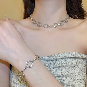 Detail shot of silver flower pendant necklace and bracelet set worn by a model