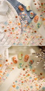 Close-up of rabbit and pumpkin embroidery nail stickers on autumn-themed manicured nails