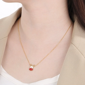 Detail of gold reindeer necklace with red and white enamel on model neck