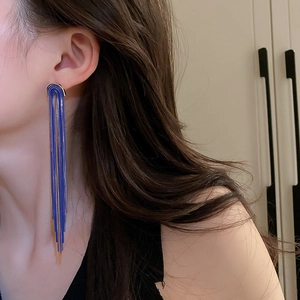 Elegant long blue tassel earrings with gold-tone links shown on a model for luxury style