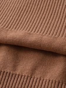 Close-up of caramel knit sweater showing high-quality ribbing and stitching detail