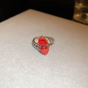 Detail view of double red heart-shaped zircon ring with pavé stones on silver band