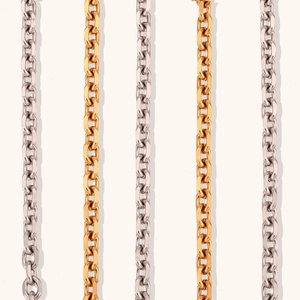 Detailed view of vertically aligned gold and silver stainless steel cable chains