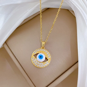Detail of crystal paved evil eye pendant in gold finish on a delicate necklace chain