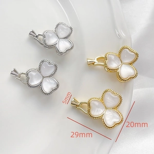 Detailed view of gold and silver clover-shaped clasps with white mother of pearl inlay