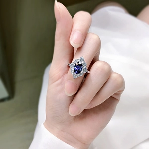 Makroaufnahme von Silberring mit ovalem blauem Saphir und Pavé-Kristallfassung