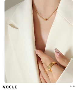 Dettaglio della collana con ciondolo a tubo placcata oro 18k e anello strutturato su modella