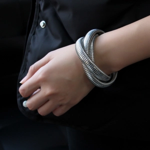 Silver multi-layer flexible stainless steel coiled snake bracelet on female wrist