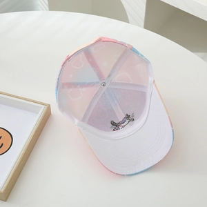 Dettaglio del ricamo a unicorno e fodera con cuori della berretta rosa da bambina con visiera