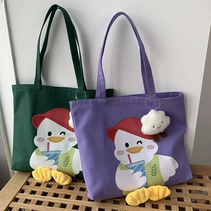 Detailed view of forest green and purple canvas tote bags with plush duck feet charms