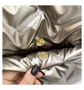 Macro view of the magnetic snap closure on champagne gold quilted tote bag material