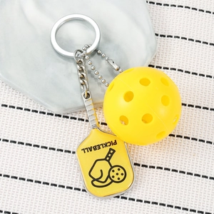 Miniature yellow pickleball paddle and ball keychain with silver metal ring and chain