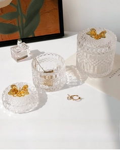 Macro view of embossed glass jars with golden butterfly lids and luxury texture