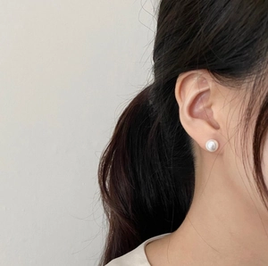 Detailed view of an elegant 925 silver earring featuring a round white pearl on earlobe
