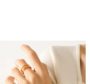 Detailed view of layered gold rings with crystal inlay worn by a model in soft light