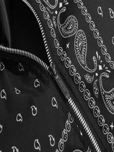 Détail de la fermeture éclair en métal et motif cachemire sur veste noire tendance