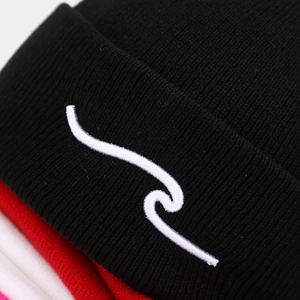 Close-up of wavy white embroidery on black knit beanie with layered red and white options